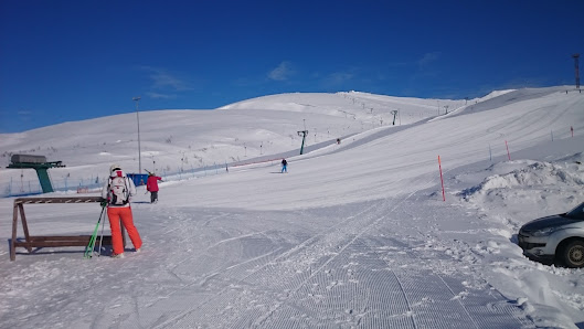 A skier glides down a slope at Kolasportland, a ski resort in Kirovsk, Russia. A charming chalet can be seen amidst the winter sports scene.