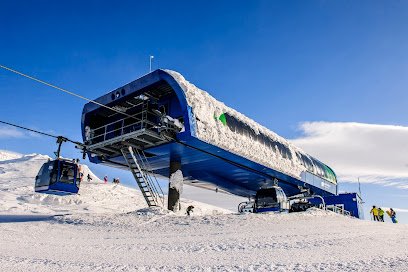 A snowmobile parked near a bustling ski resort in Big Wood Kirovsk Russia complete with a ski lift indicating a popular winter sports scene.
