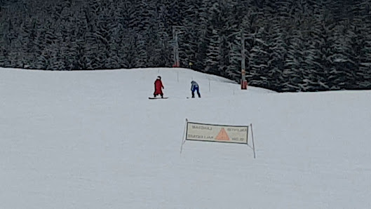 A skier enjoying a breathtaking winter scene at Télécabine de l'Essert in Abondance France. The ski resort and lift dot the snow-covered landscape with potential glimpses of a family skiing.