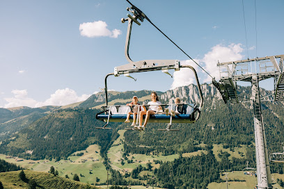 Skiers enjoying an exhilarating day at the Wiriehornbahnen ski resort in Diemtigen, Switzerland. Ski lift lines streak through the pristine white snow, leading to charming chalets nestled at the base of the majestic mountain.