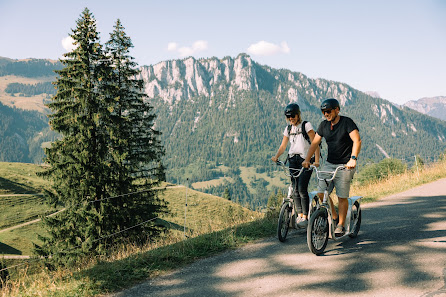 A mountain biker enjoying a sunny day at Wiriehornbahnen in Bernese Oberland, Switzerland. A quaint chalet can be seen in the beautiful mountainous backdrop.