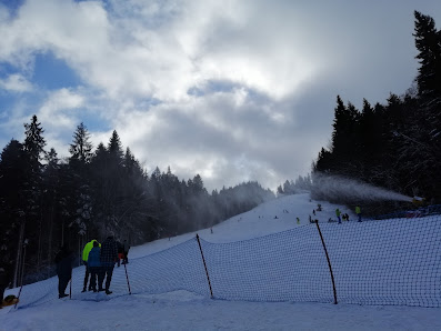 Winter sports scene at Clăbucet in Telescaun, Predeal, Romania with a chalet, a sports center and picturesque snowy scenery in a ski resort.