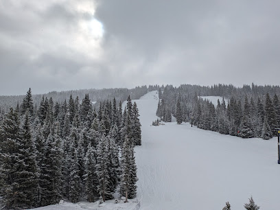 View of Antelope Butte ski resort in Shell, Wyoming featuring a ski lift, snow-covered slopes, mountain scenery, and individuals enjoying winter sports.
