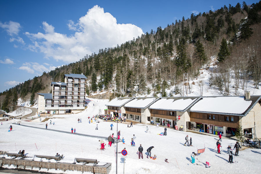 View of the Col de Rousset ski resort in France, featuring a winter sports scene with a chalet and ski lift in the background amidst snow-covered surroundings.