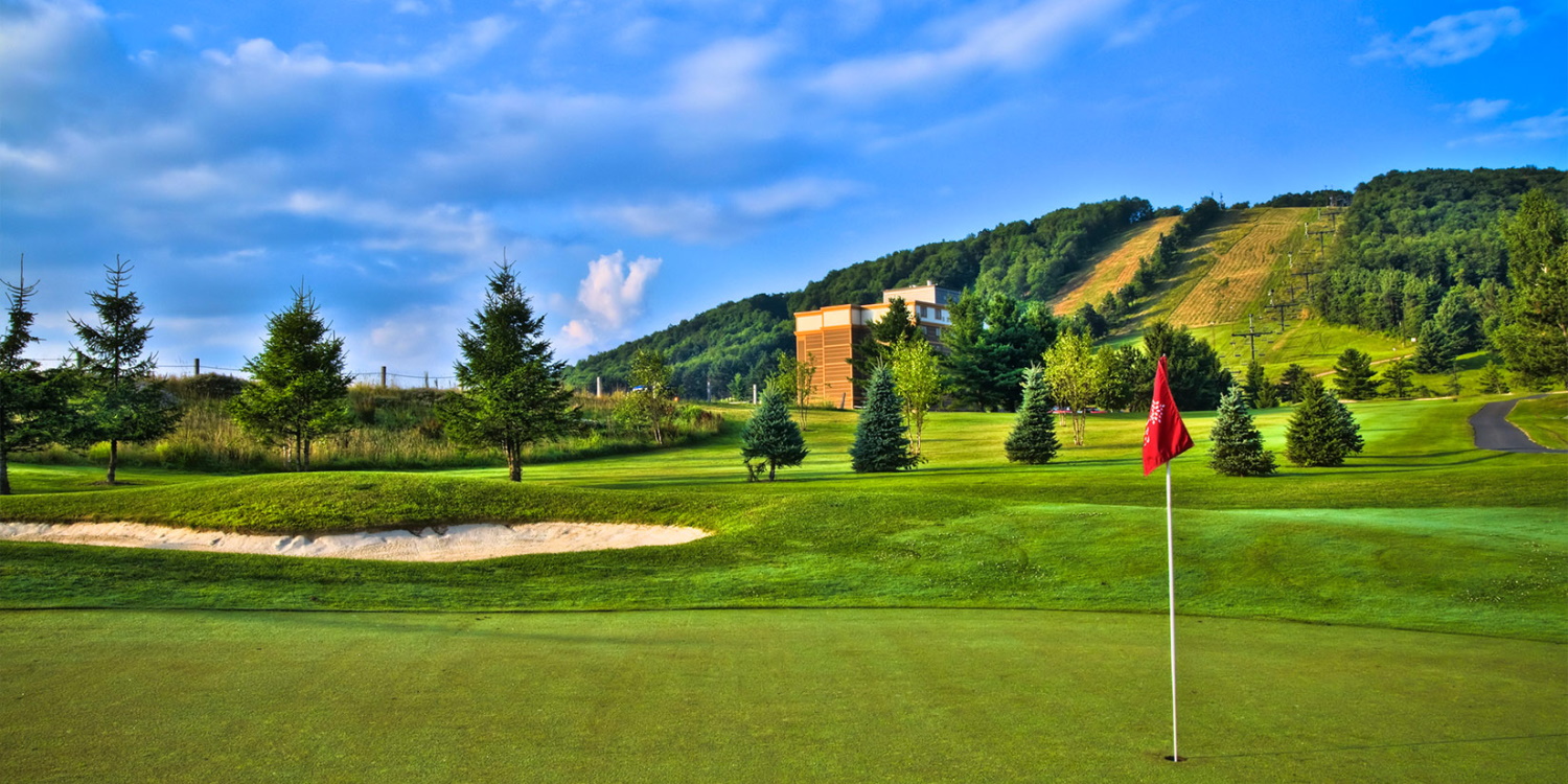 Wisp Resort in USA - a golf course with a red flag on the green.