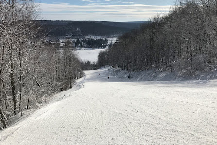 Winter scene at Wisp Resort in Maryland, USA, with a skier gliding down the snow-covered slopes, ski lift in the background.