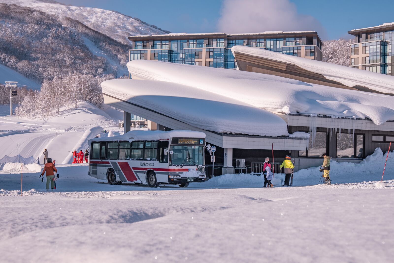 Niseko United in Japan: a bus parked in the snow in front of a building.