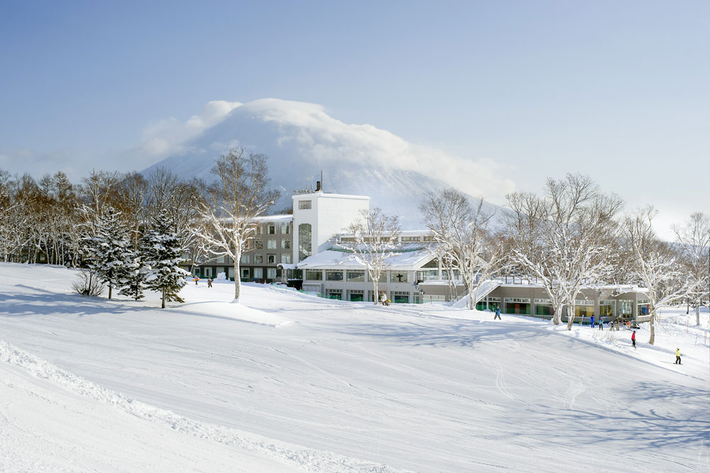 View of Niseko United in Niseko Village, Hokkaido, Japan, featuring a breathtaking winter landscape with a bustling winter sports center and ski resort.