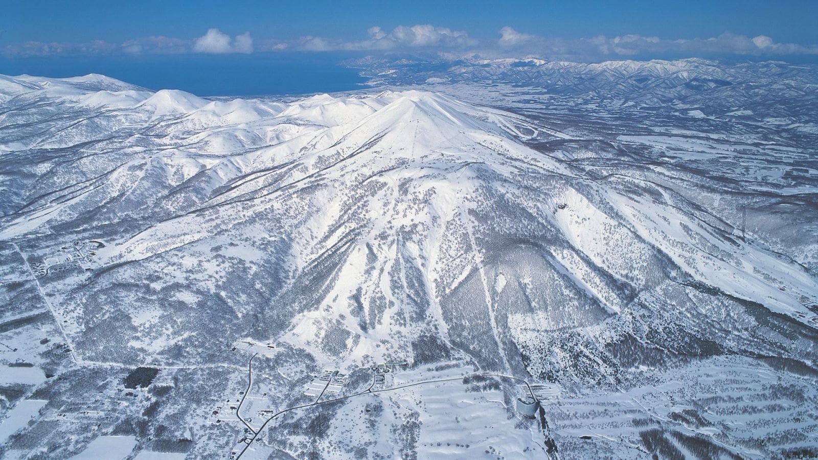 Niseko United in Japan - a view of snow covered mountains from a plane.