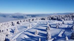 Winter scene at Station du Semnoz, France, showcasing a vibrant ski resort amid stunning winter scenery, with a quaint chalet adding to the charm.