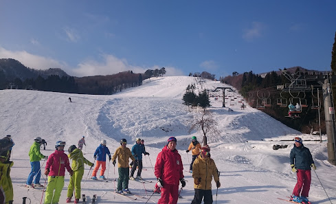 Winter sports scene at Okukan, a ski resort in Toyooka, Japan, featuring stunning winter scenery, various skiing facilities, and a cozy chalet.