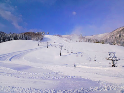 A breathtaking winter scene at Okukan ski resort in Toyooka, Japan, showcasing snow-covered slopes lively with winter sports activities.