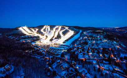 Ski resort at Sommet Olympia in Quebec, Canada featuring snow-covered slopes and a ski lift, creating a captivating winter sports scene.