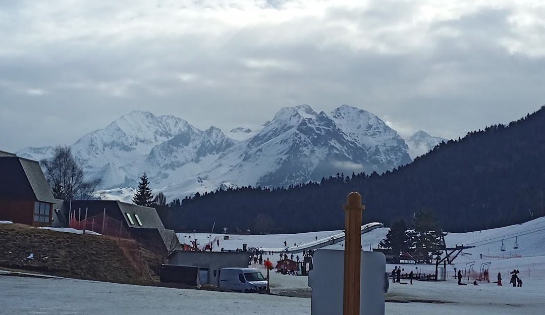 Winter sports scene at Val Louron in France, featuring a charming chalet nestled against a magnificent mountain backdrop amidst stunning winter scenery.