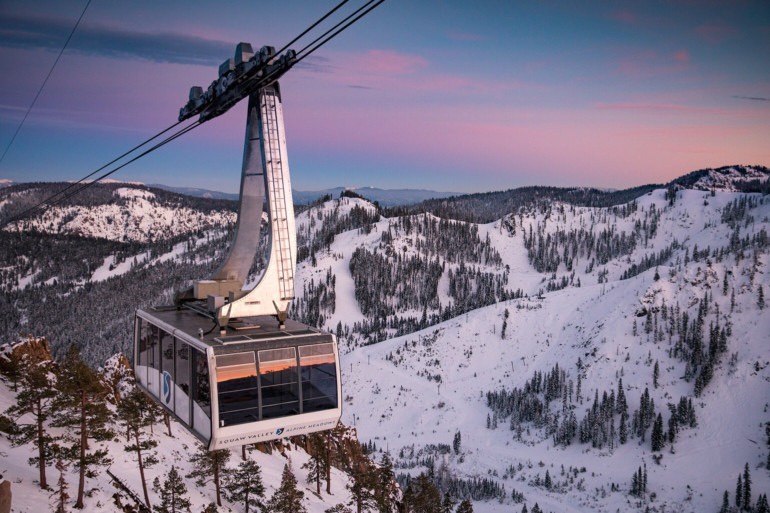 Image showcasing a ski lift ascending up a snowy mountain at Palisades Tahoe ski resort in Lake Tahoe, California. Winter sports enthusiasts in action, amidst picturesque winter scenery.