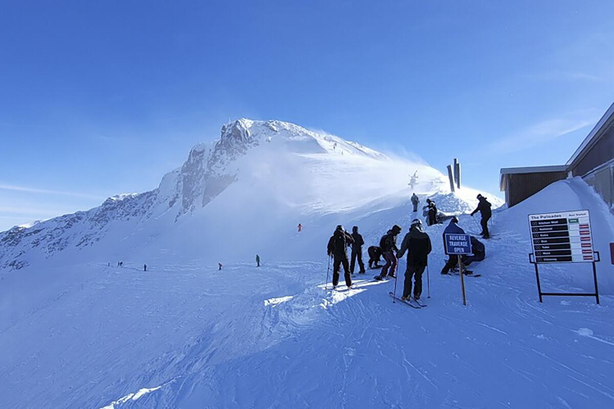 Palisades Tahoe in USA - a group of people walking up the side of a mountain.