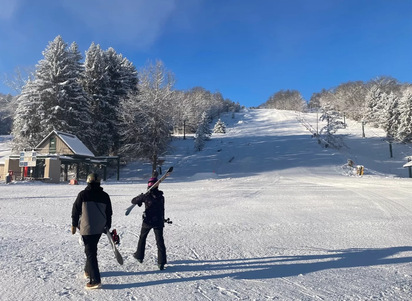 Kissing Bridge in USA - two people walking across a snow covered field.