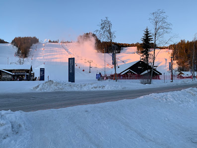 View of Skimore Kongsberg ski resort in Norway, showcasing the winter sports centre amidst a stunning winter scenery. Visible elements include a ski lift amidst snowy landscapes.