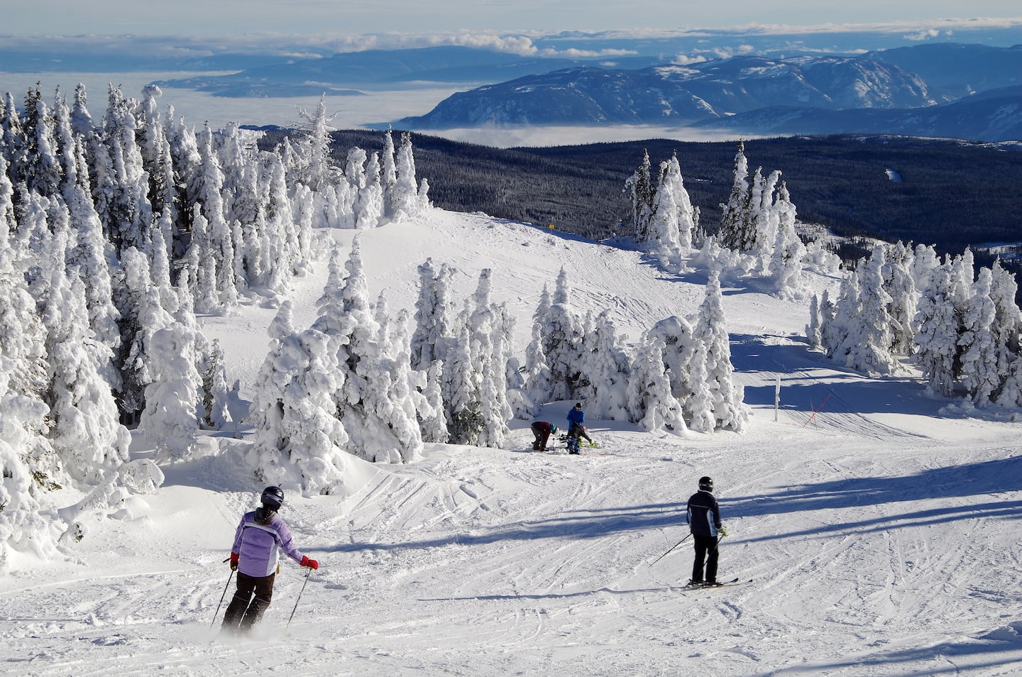 Sun Peaks in Canada - a group of people skiing down a snow covered mountain.