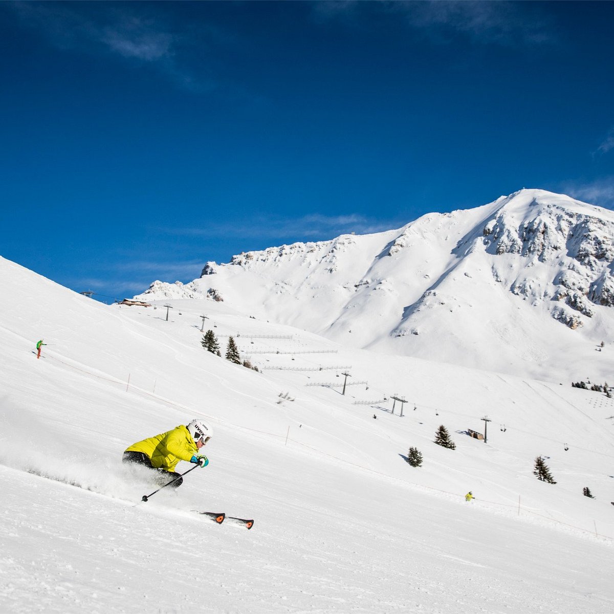 Ski Center Latemar in Italy - a person skiing down a snow covered mountain.